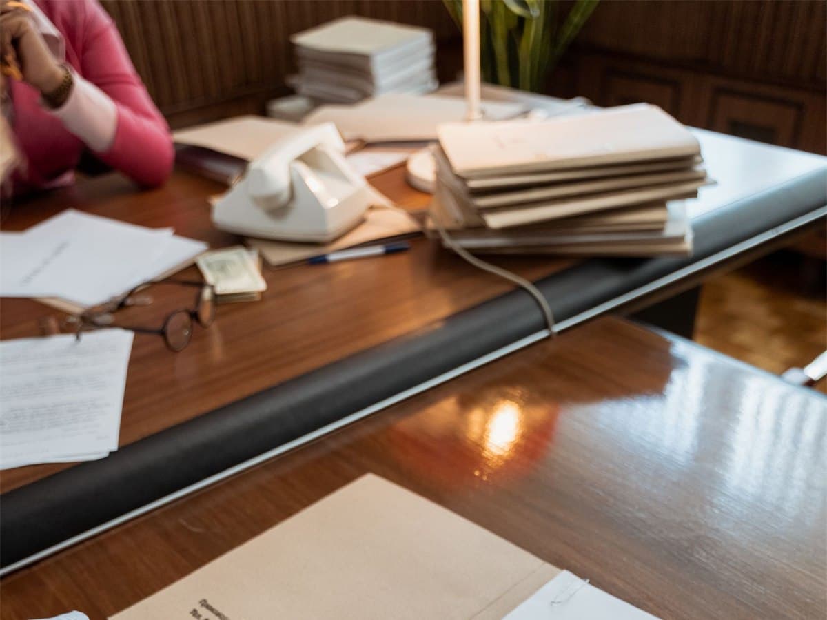 Export paperwork laid out across a desk under warm window light